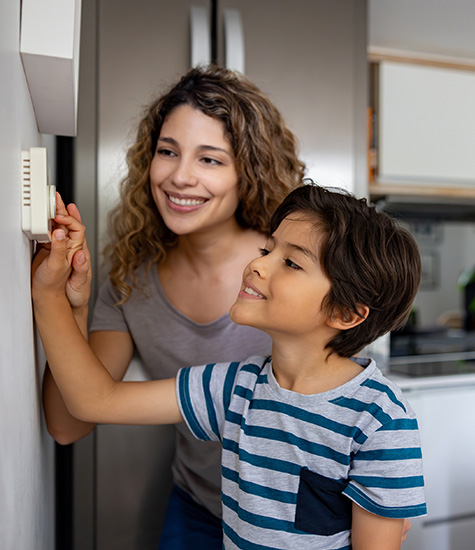 a mother and son setting their thermostat